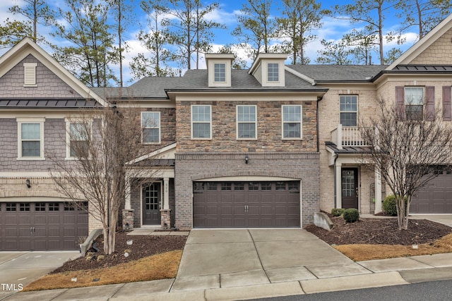 multi unit property featuring brick siding, a shingled roof, an attached garage, stone siding, and driveway