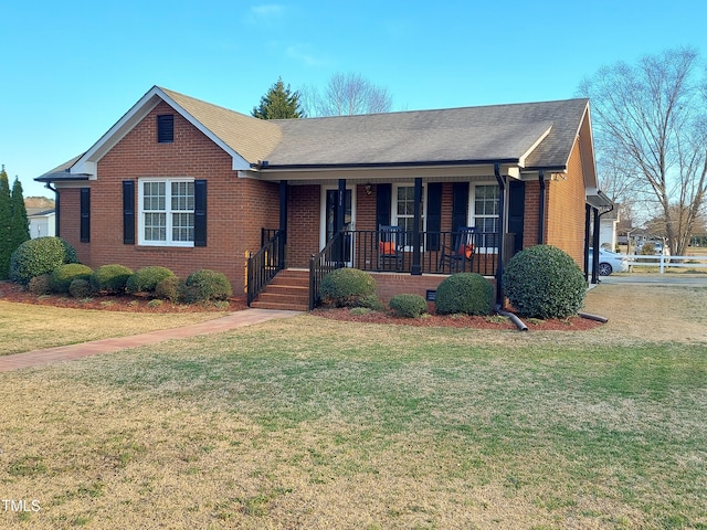 single story home with covered porch, roof with shingles, a front yard, and brick siding