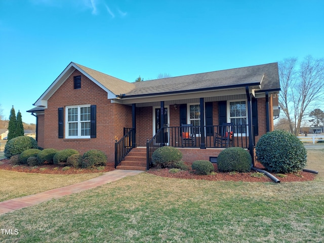 view of front of house featuring covered porch, a front yard, and brick siding