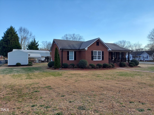 view of front of home featuring a porch, a front lawn, and brick siding