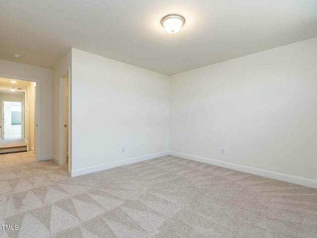 unfurnished room featuring light carpet and baseboards