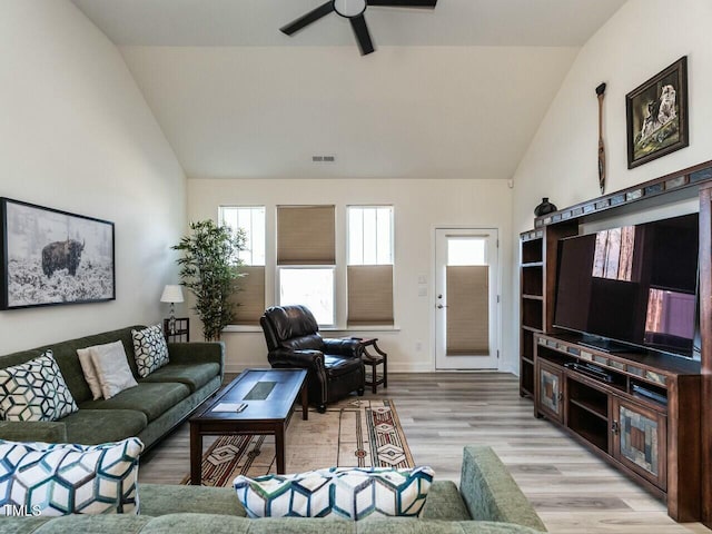 living room featuring high vaulted ceiling, light wood-style flooring, visible vents, baseboards, and a ceiling fan