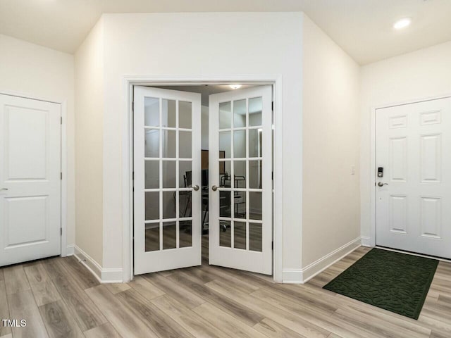 doorway with baseboards, wood finished floors, and french doors