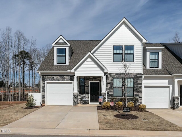 view of front of home with a garage, driveway, and roof with shingles