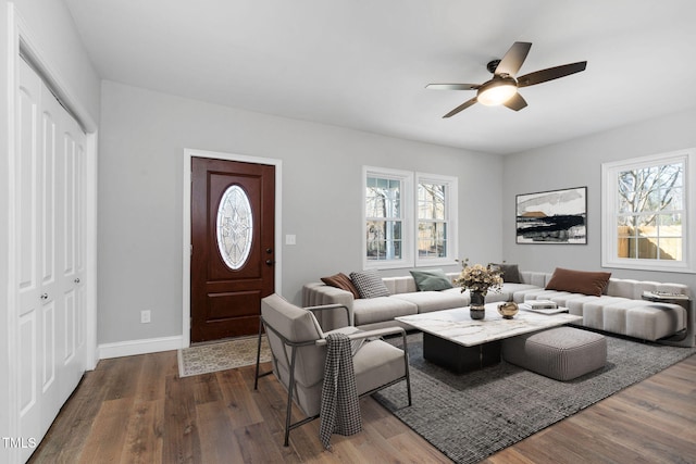 living area with a ceiling fan, a wealth of natural light, and wood finished floors