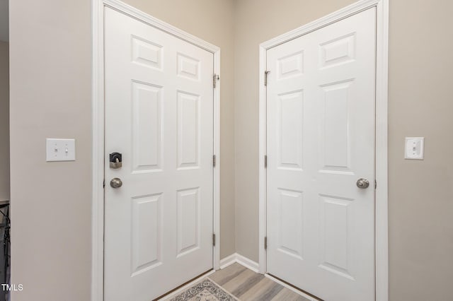 doorway to outside with light wood-type flooring and baseboards