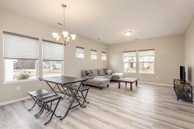 dining space with a chandelier, visible vents, light wood-style flooring, and baseboards