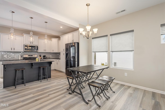 dining room with recessed lighting, visible vents, light wood-style floors, a chandelier, and baseboards