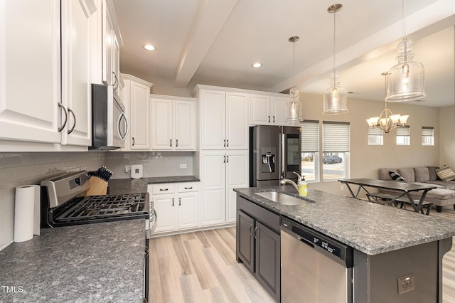 kitchen featuring stainless steel appliances, beamed ceiling, a sink, and white cabinets