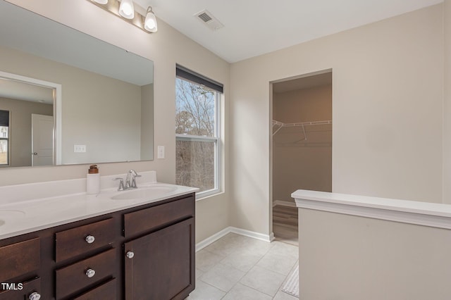 bathroom featuring double vanity, baseboards, visible vents, tile patterned floors, and a sink