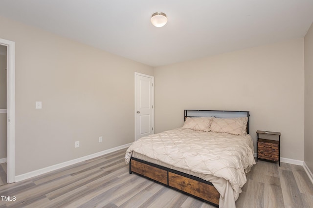 bedroom featuring light wood-style floors and baseboards