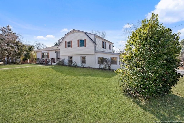 view of front of property with a front lawn and a gambrel roof