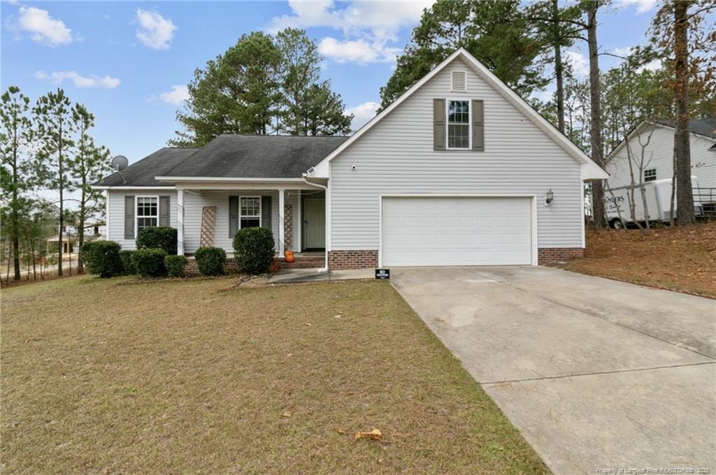 traditional home featuring a front yard, driveway, and an attached garage