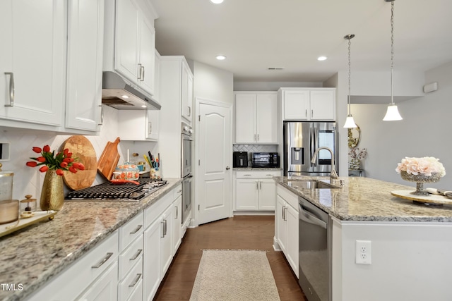 kitchen with white cabinets, a kitchen island with sink, stainless steel appliances, under cabinet range hood, and a sink