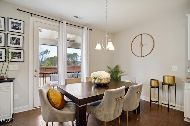 dining room featuring baseboards, visible vents, dark wood finished floors, and a chandelier