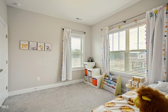 bedroom with baseboards, visible vents, and light colored carpet