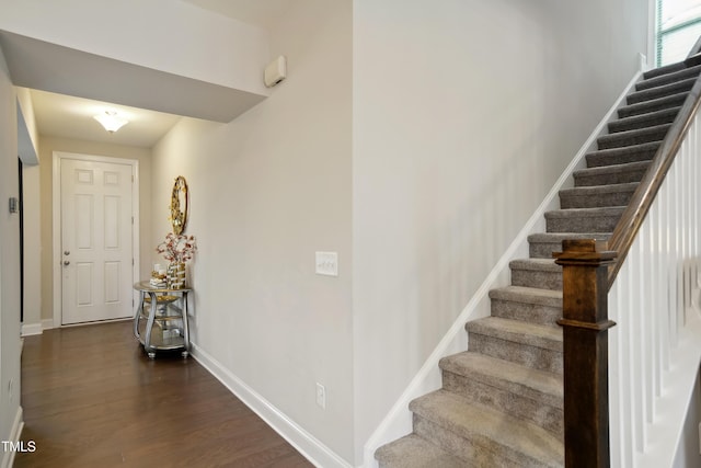 stairway featuring baseboards and wood finished floors