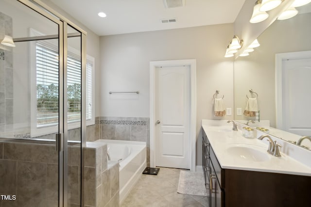 bathroom featuring tile patterned flooring, visible vents, a sink, and a bath