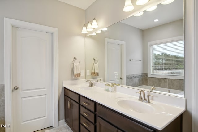 full bathroom featuring a garden tub, a sink, and double vanity