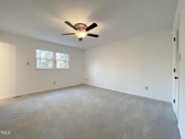 empty room featuring a ceiling fan, carpet, visible vents, and baseboards