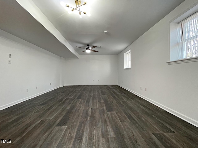 unfurnished room featuring dark wood-style floors, ceiling fan, and baseboards