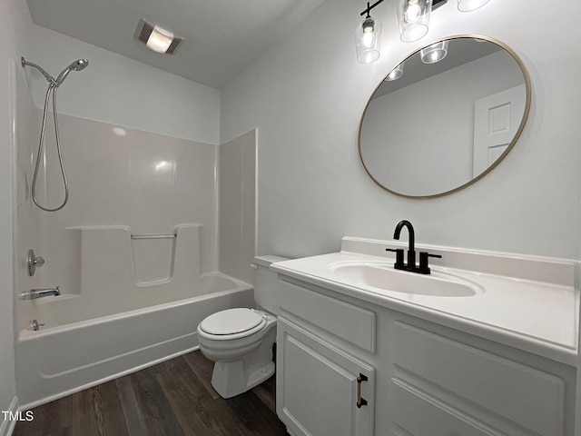 bathroom with toilet, washtub / shower combination, wood finished floors, and vanity