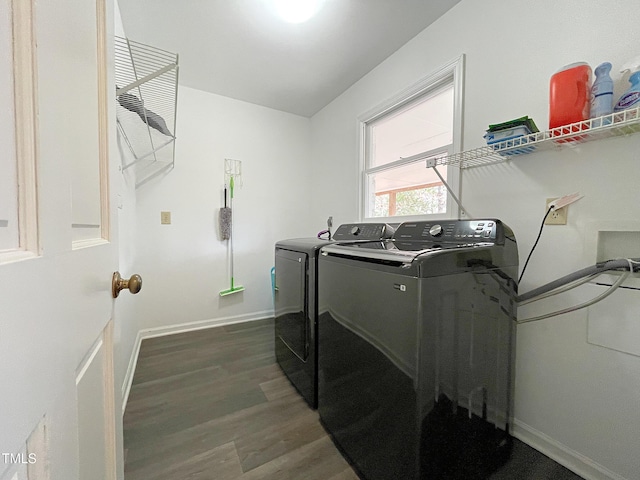 washroom with laundry area, washer and clothes dryer, baseboards, and wood finished floors