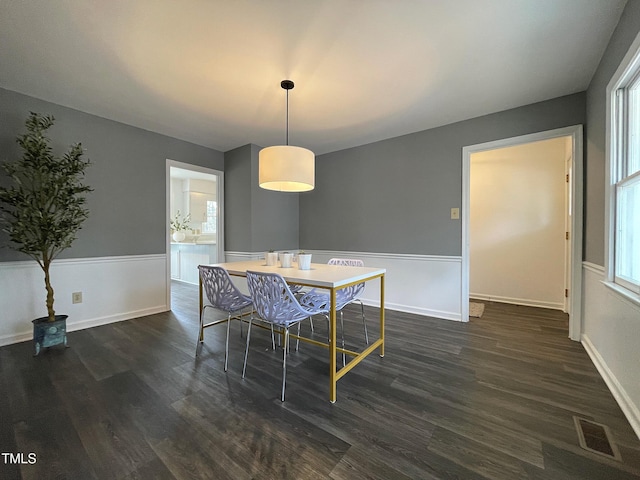 dining room featuring dark wood finished floors, visible vents, and baseboards