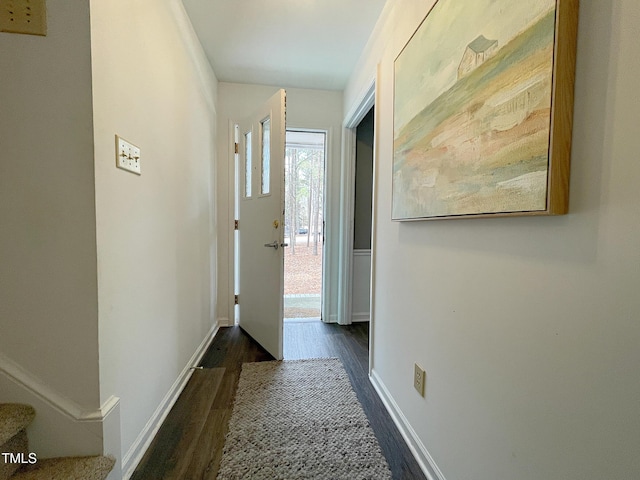 doorway with dark wood-style floors, stairs, and baseboards