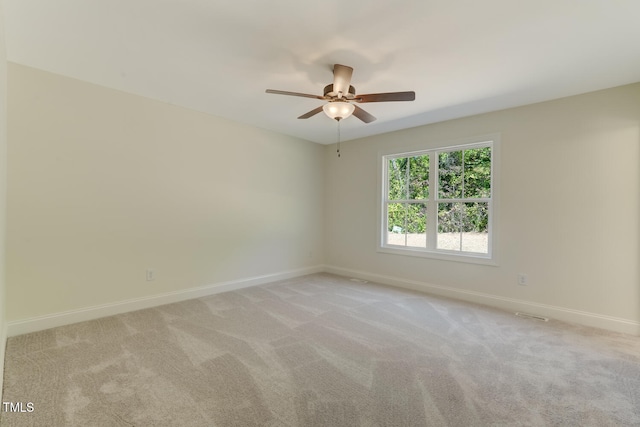 unfurnished room with baseboards, a ceiling fan, and light colored carpet