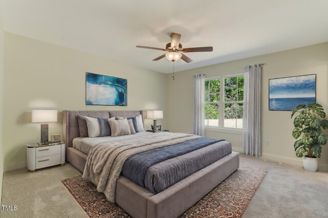 bedroom featuring light carpet, ceiling fan, and baseboards