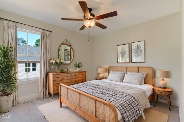 bedroom with a ceiling fan, visible vents, light carpet, and baseboards