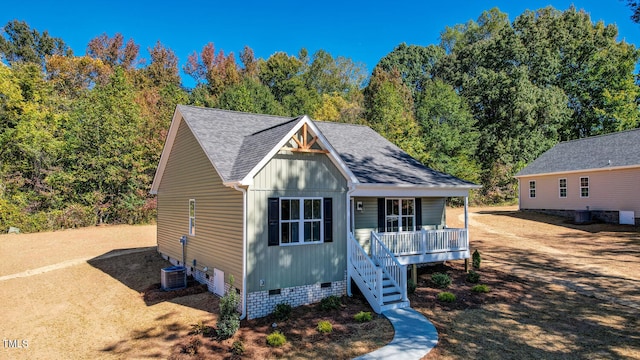 view of front of property with crawl space, covered porch, a shingled roof, and central AC unit