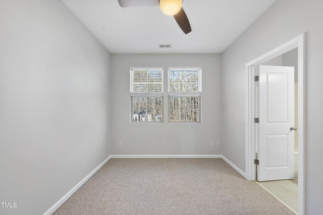 unfurnished room with light colored carpet, ceiling fan, visible vents, and baseboards