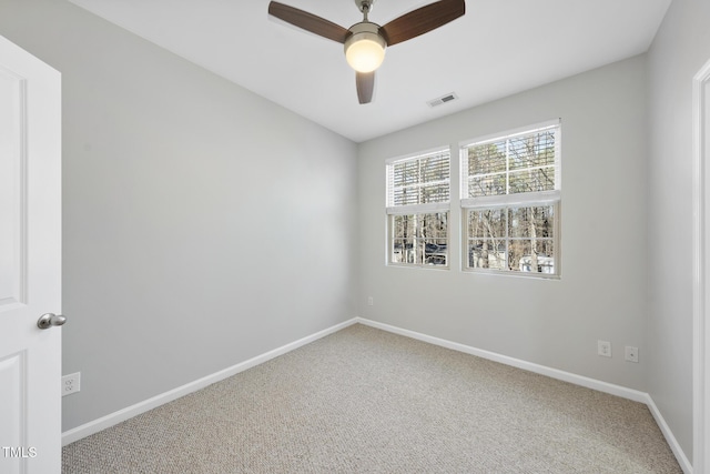 empty room featuring visible vents, carpet flooring, a ceiling fan, and baseboards