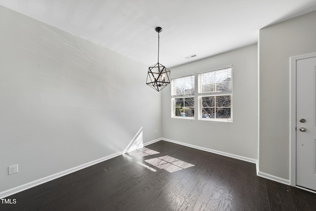 unfurnished dining area with an inviting chandelier, visible vents, baseboards, and wood finished floors