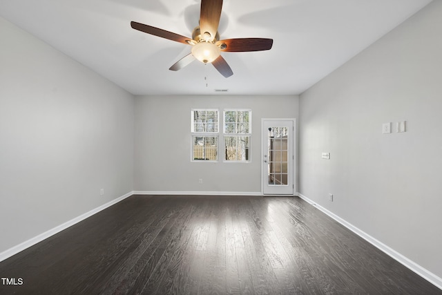 spare room with dark wood-style floors, baseboards, and a ceiling fan