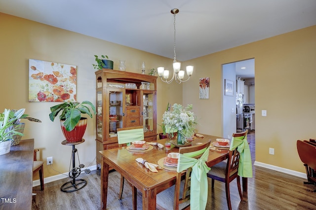 dining room featuring wood finished floors, baseboards, and a chandelier