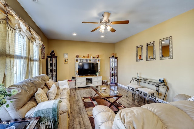 living area with wood finished floors, recessed lighting, a ceiling fan, and baseboards