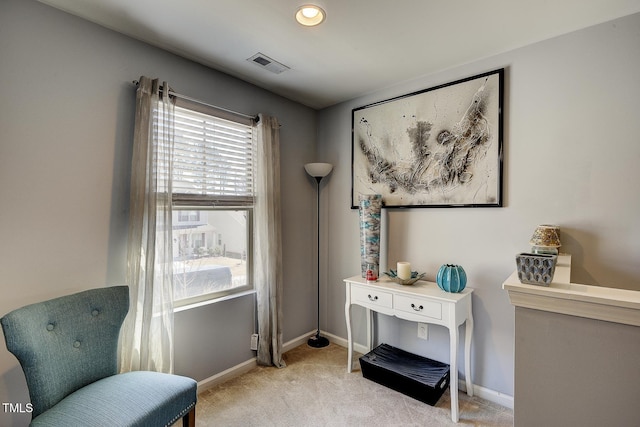 sitting room with visible vents, light colored carpet, and baseboards