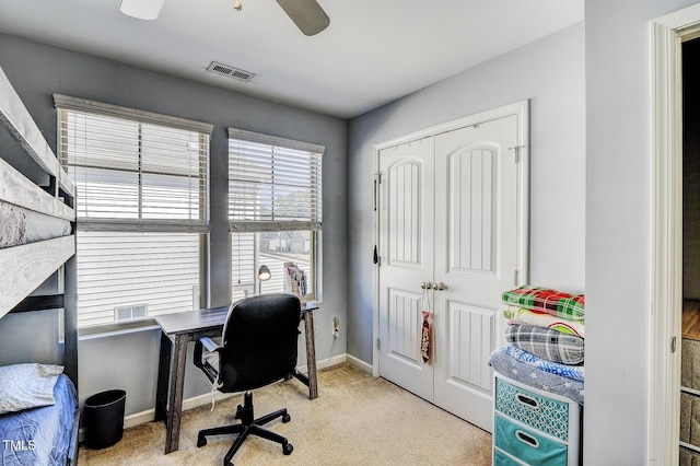 carpeted home office with a ceiling fan, baseboards, and visible vents