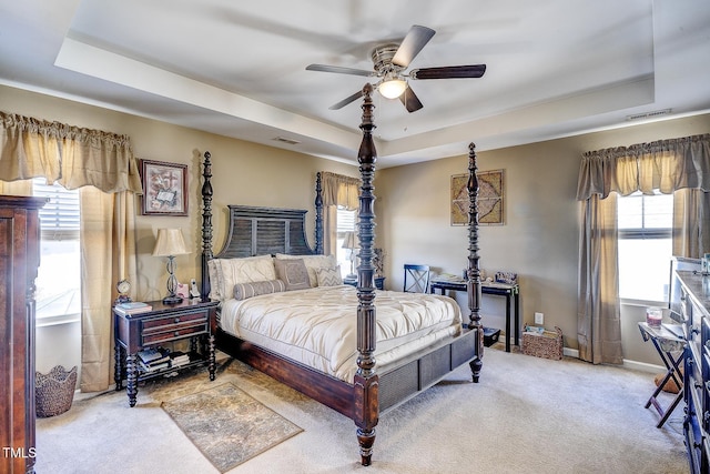 bedroom with visible vents, baseboards, carpet, and a tray ceiling