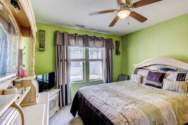 bedroom with a ceiling fan, light colored carpet, and visible vents