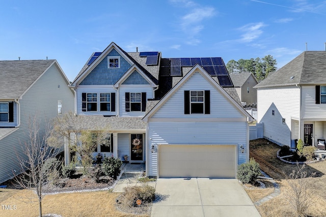 view of front facade with solar panels, concrete driveway, and an attached garage