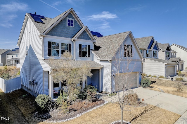 view of front of home with concrete driveway, roof with shingles, a garage, and fence