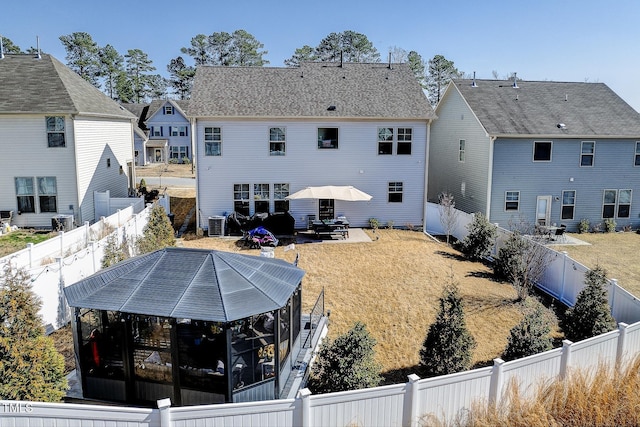 rear view of property with a fenced backyard and a patio area