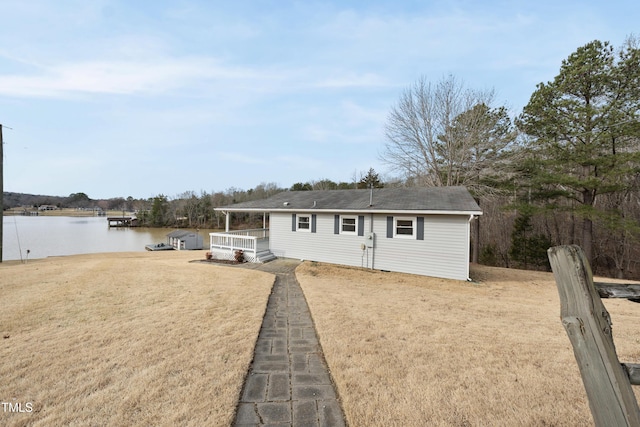 view of front of home with a water view and a front lawn