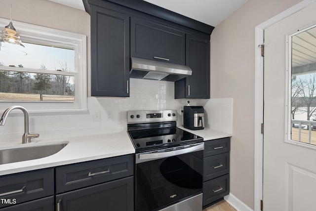 kitchen with a sink, exhaust hood, light countertops, stainless steel electric range, and decorative backsplash