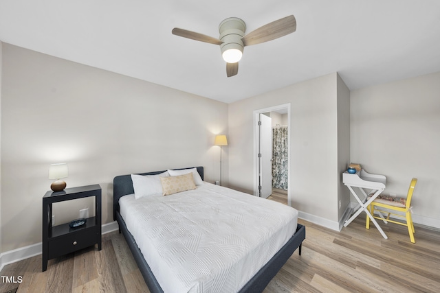 bedroom with ceiling fan, wood finished floors, and baseboards