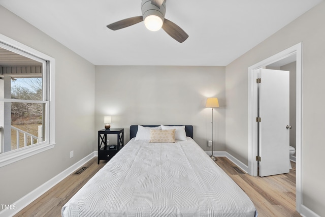 bedroom featuring baseboards, visible vents, ceiling fan, and wood finished floors